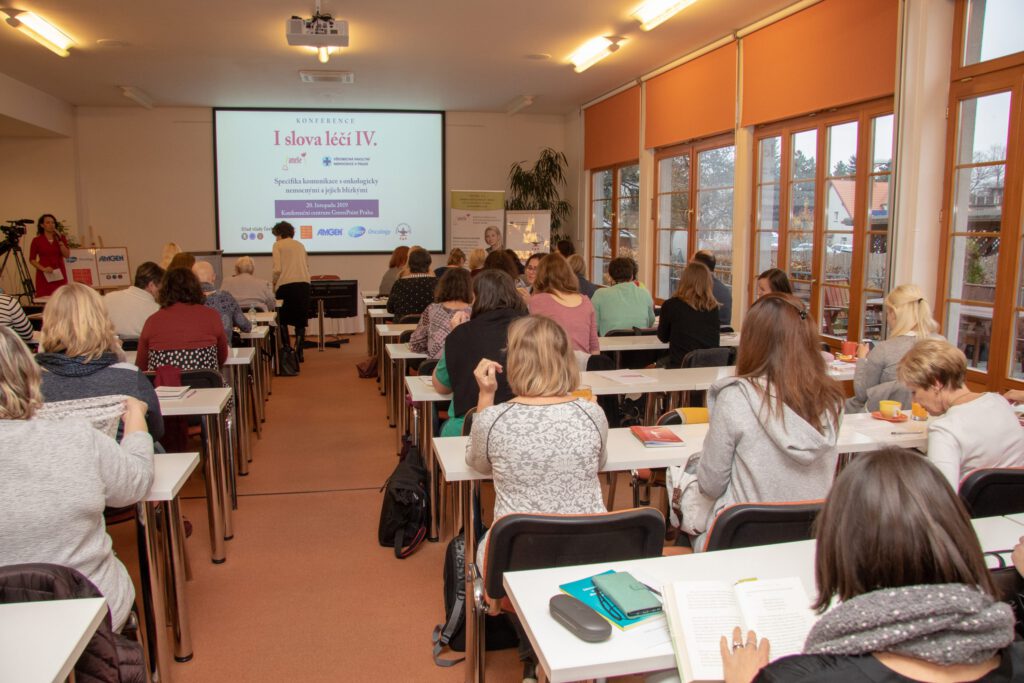 Obrázek konferenční místnosti s publikem